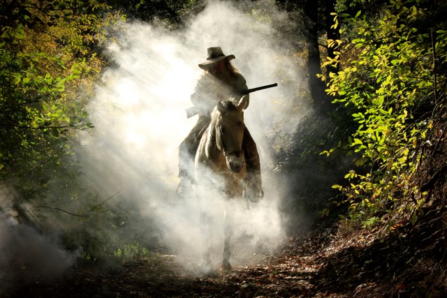 image of horseman going through smoke in the woods