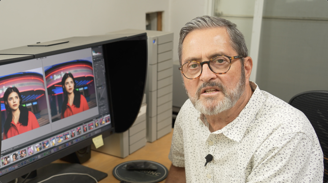 Older man in glasses edits photos of a woman on a dual-monitor setup.